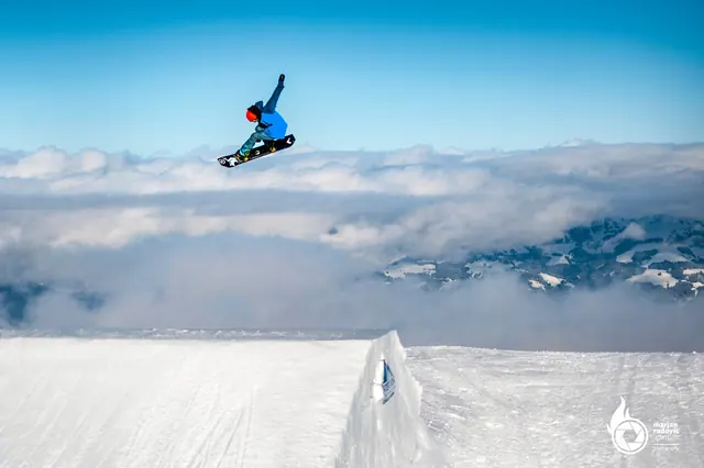 Snowboarder in the air above the clouds